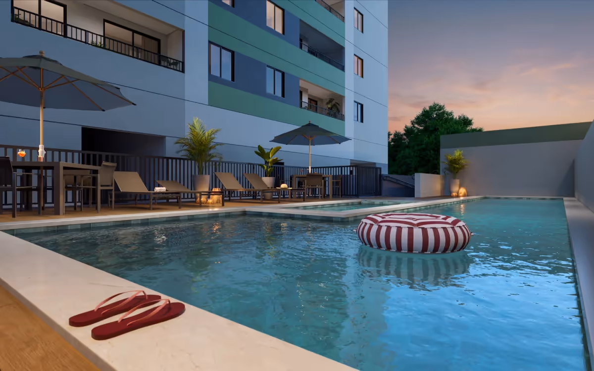 Piscina ao entardecer, com mesas e ombrelones — Residencial Momi