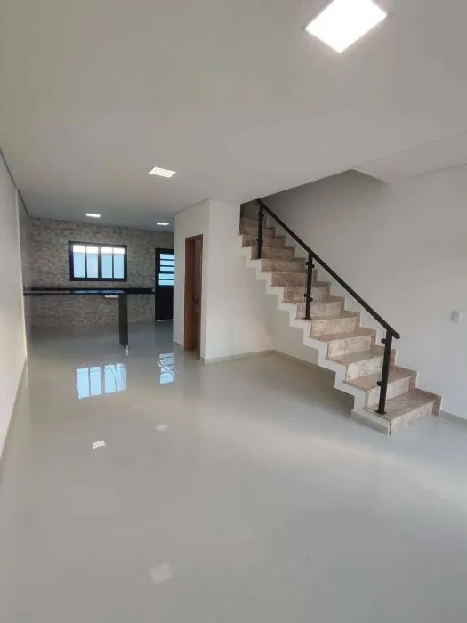 Sala com a escada de acesso ao piso superior — Casa em Brás Cubas, 2 suítes, 2 vagas e quintal